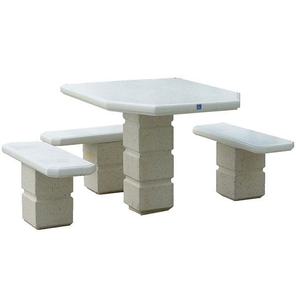 A footed square pedestal concrete table set with three pedestal benches. A small blue handicapped symbol is visible on the side of the table.